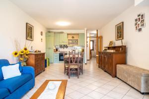 a living room with a blue couch and a kitchen at Casa Ester a due passi dal lago in Germignaga
