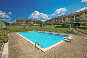 a swimming pool with a bench next to a building at Casa Ester a due passi dal lago in Germignaga