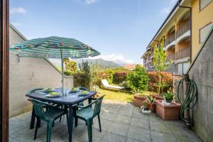 a table and chairs with an umbrella on a patio at Casa Ester a due passi dal lago in Germignaga