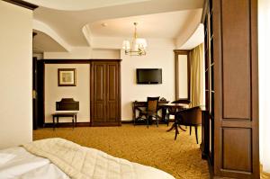 ein Hotelzimmer mit Bett und Esszimmer in der Unterkunft Hotel Bellaria in Iaşi