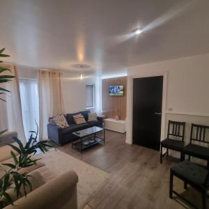 a living room with a couch and a table at Cozy Flat with Parking in Goodmayes