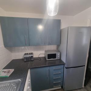 a kitchen with a sink and a refrigerator at Cozy Flat with Parking in Goodmayes +5 photos