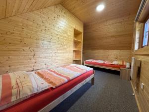 a bedroom with two beds in a wooden room at Chalupa Nella II. in Velké Karlovice