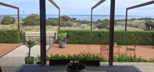 a patio with chairs and a view of the ocean at The Rusty Kangaroo Hideaway - Ocean-View - Full Booking Service, Ferry, Experiences, Tour Option in Penneshaw +25 photos