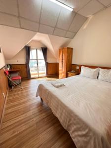 a bedroom with a large bed and a large window at Hoa Cattleya Hotel in Da Lat