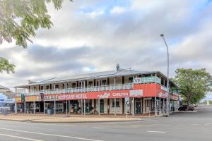 a red building on the corner of a street at Hotel Shakespeare Barcaldine in Barcaldine