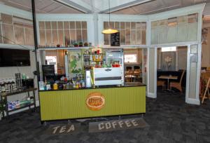 a coffee shop with a yellow and green counter at Hotel Shakespeare Barcaldine in Barcaldine