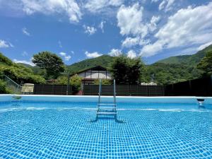 a view of a swimming pool with mountains in the background at 貸切宿さうなす in Nasushiobara