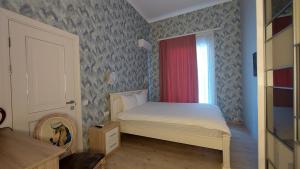 ein kleines Schlafzimmer mit einem Bett und einem Fenster in der Unterkunft Siena Hotel in Odessa