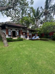 a house with a lawn in front of it at Villa Riens Dream in Karangasem