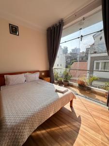 a bedroom with a bed and a large window at Hoa Cattleya Hotel in Da Lat