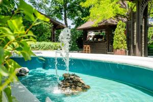 ein Schwimmbecken mit einem Springbrunnen in der Mitte in der Unterkunft Hotel Bellaria in Iaşi