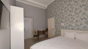 ein Schlafzimmer mit einem weißen Bett und einem Schreibtisch in der Unterkunft Siena Hotel in Odessa