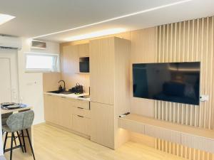 a kitchen with a large flat screen tv on a wall at Harbor Hideaway Balatonfüred in Balatonfüred