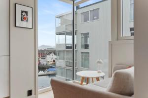a living room with a couch and a large window at Exclusive apartment in Lofoten in Svolvær
