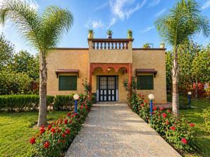 ein Haus mit Palmen und einem davorliegenden Gehweg in der Unterkunft Villa Eden Atlas Ourika in Sbiti