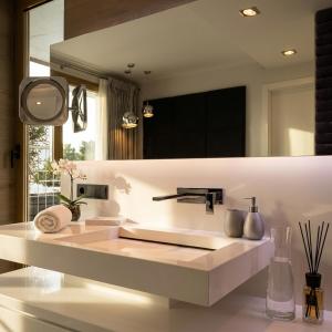 a bathroom with a sink and a large mirror at Sky & Spa Luxury Residence in Warsaw