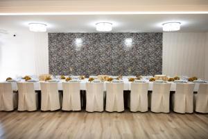 a conference room with white tables and chairs and a wall at Pelikan in Aleksandrów Łódzki