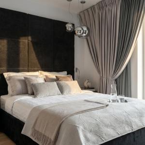 a bedroom with a large bed with a black headboard at Sky & Spa Luxury Residence in Warsaw