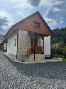 a small stone house with a porch and a balcony at Chalupa Nella II. in Velké Karlovice