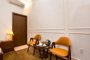 a room with two chairs and a table and a door at Indochine Apartments in Ho Chi Minh City