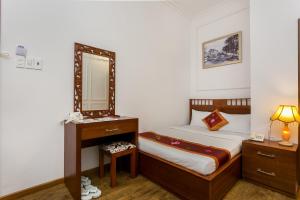 a bedroom with a bed with a mirror and a dresser at Indochine Apartments in Ho Chi Minh City