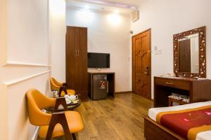 a hotel room with a bed and a television at Indochine Apartments in Ho Chi Minh City