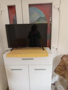 a television on top of a white dresser at Fantazija Tešnjar Apartment in Valjevo +2 photos