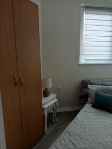 a bedroom with a bed and a table with a lamp at Fantazija Tešnjar Apartment in Valjevo