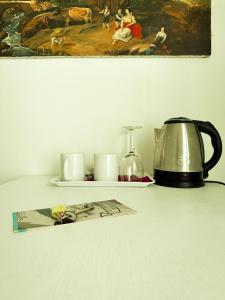 a tea kettle and candles on a shelf with a painting at Affittacamere Giulia in Vernazza