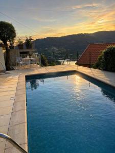 a large swimming pool in a backyard with a table at Casa da Lage - Piscina privada - Vistas rio - "Gerês" in Geres