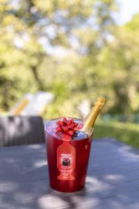 a bottle of champagne in a red cup on a table at Casinha de campo in Geres