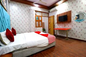 a bedroom with a bed and a table and a television at Hotel Hindon Residency "Couple Friendly" in Ghaziabad