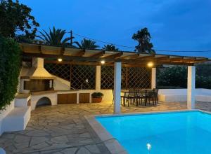 a backyard with a swimming pool and a pergola at Plepi's Seaside Villa in Plépi