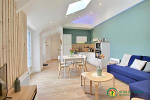 a living room with a blue couch and a table at Ty brestivan in Theix