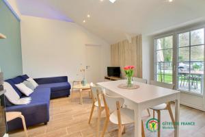 a living room with a blue couch and a table at Ty brestivan in Theix
