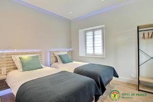 two beds in a room with a window at Ty brestivan in Theix +21 photos