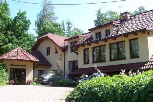 una casa con un coche aparcado delante de ella en Gościniec Nad Potokiem, en Karpacz