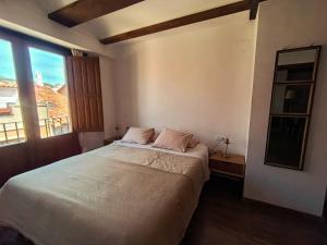 a bedroom with a bed and a large window at Apartamentos Casa Memé in Mora de Rubielos