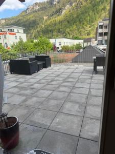 a view of a patio with benches and a mountain at Hotel ilufa in Meiringen
