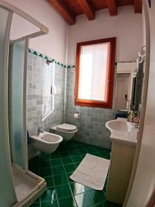 a bathroom with two sinks and a toilet and a window at Dietro la piazza in Marostica