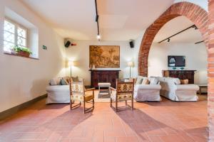 a living room with white furniture and an archway at Tenuta La Fratta in Sinalunga