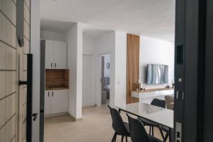a kitchen and living room with a table and chairs at Salt & Serenity Apartment in Orikum