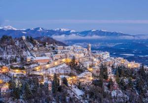 a town on a mountain in the snow at night at Casa del Moro al Sacro Monte app1 in Varese