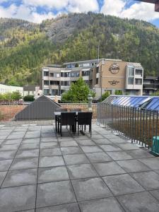a patio with a table and benches in front of a building at Hotel ilufa in Meiringen