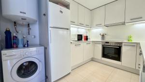 a kitchen with a white refrigerator and a washing machine at Esglesia 7 2-4 in L'Estartit