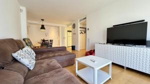 a living room with a couch and a flat screen tv at Esglesia 7 2-4 in L'Estartit