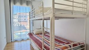 a bedroom with two bunk beds and a window at Esglesia 7 2-4 in L'Estartit