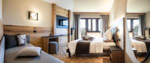 a hotel room with two beds and a couch at Hotel Arcobaleno in Fai della Paganella +159 photos