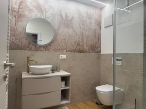 ein Badezimmer mit Waschbecken, Toilette und Spiegel in der Unterkunft P-Hosting S3 in Schlier